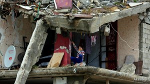 A Palestinian girl sits inside a room of her family's building which was damaged in last summer's Israel-Hamas war, in the Shijaiyah neighborhood of Gaza City, northern Gaza Strip, Monday, Feb. 23, 2015. (AP Photo/Adel Hana)